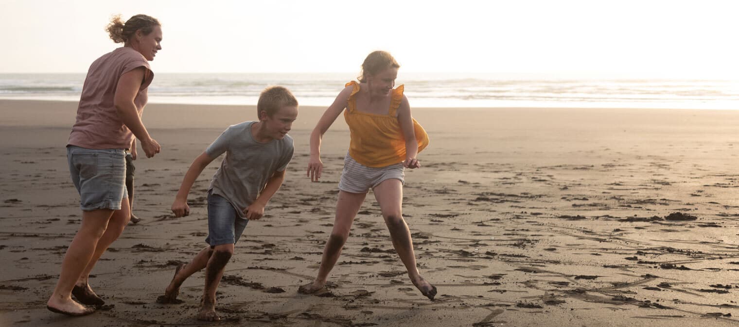 Mother and children playing at the beach
