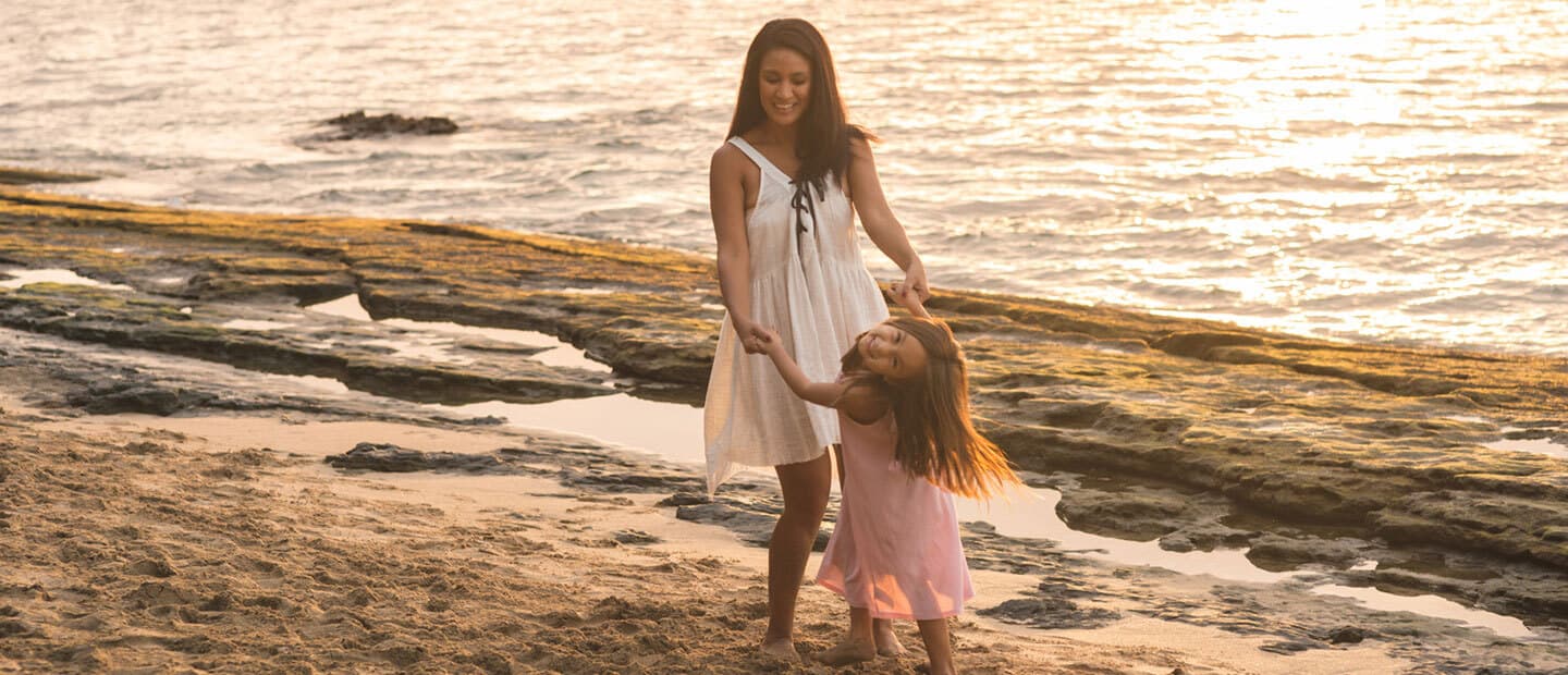 a woman dancing with her daughter on the beach