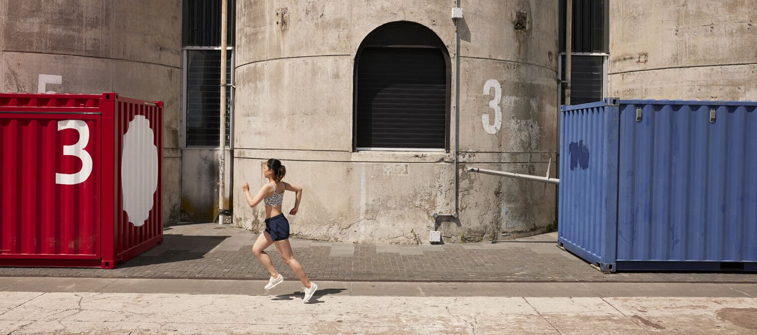 Lady running outside past buildings