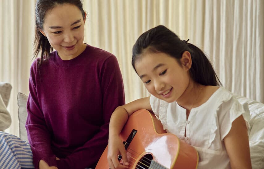 Woman and child playing guitar