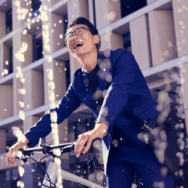 man joyfully walking through water fountain