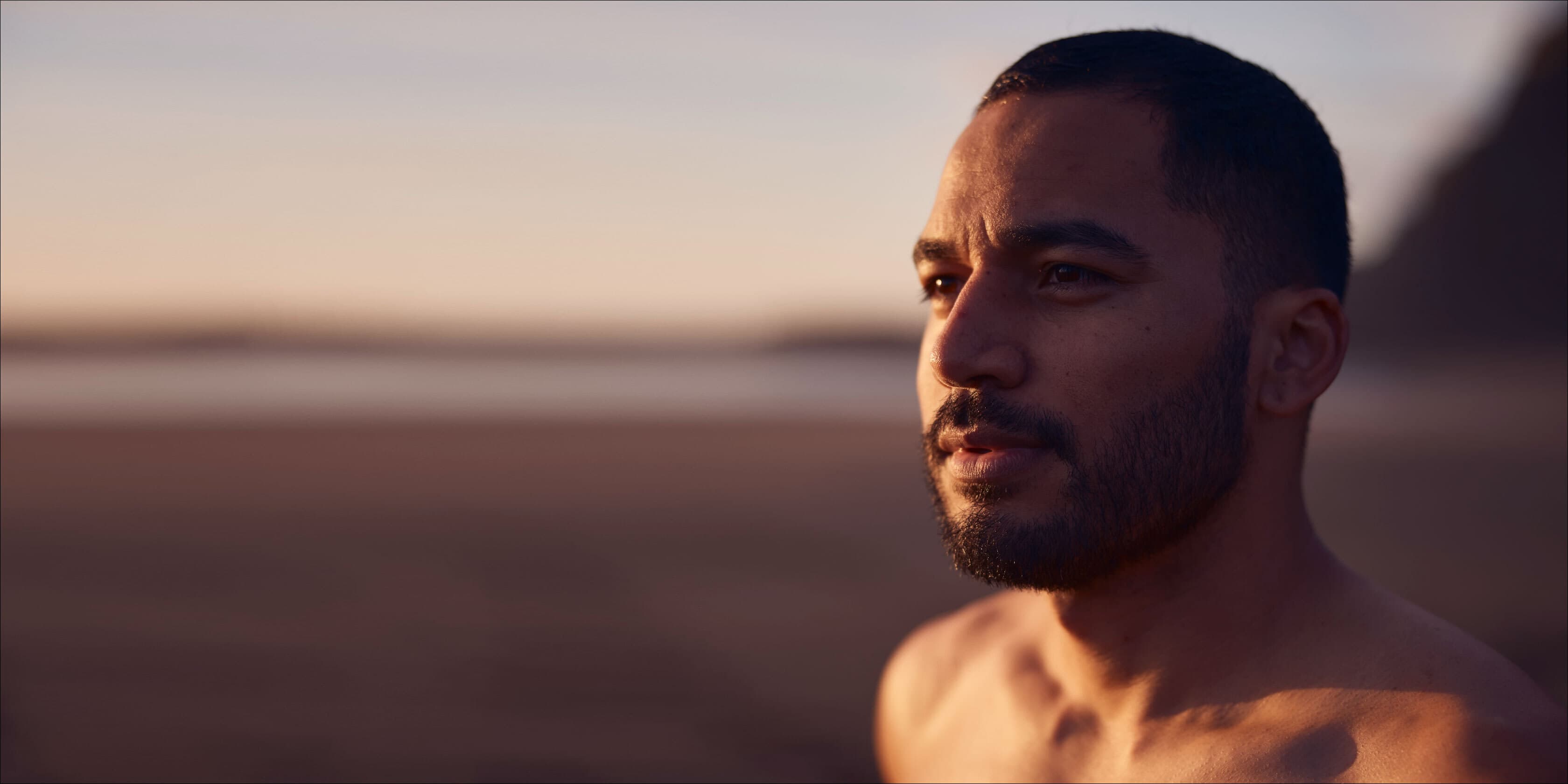 A man staring off at the sunset