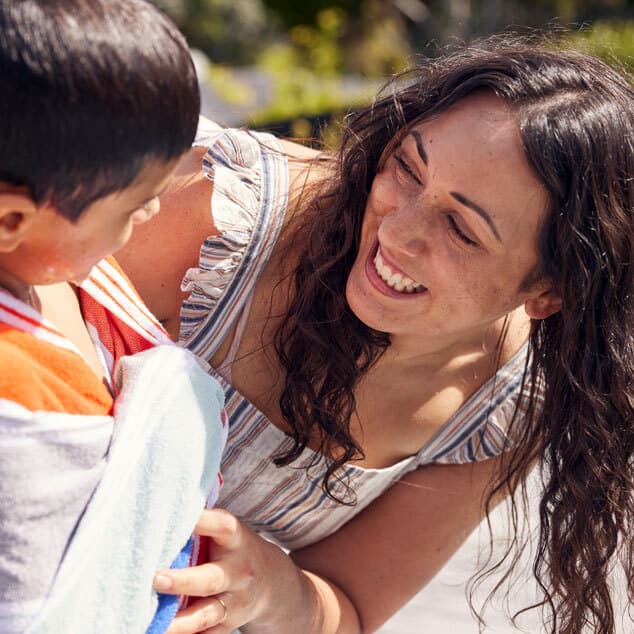 Mum helping son with towel after swimming