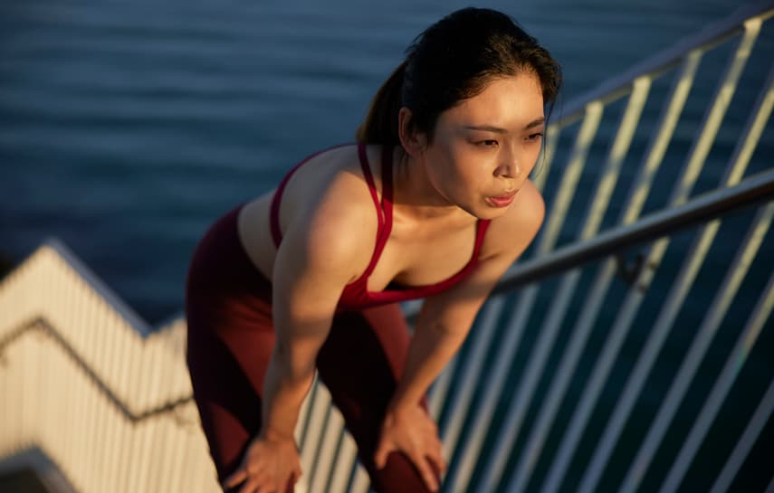Woman taking a break from running up stairs