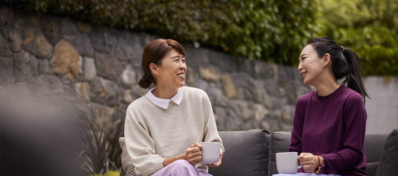 two friends drinking coffee and laughing
