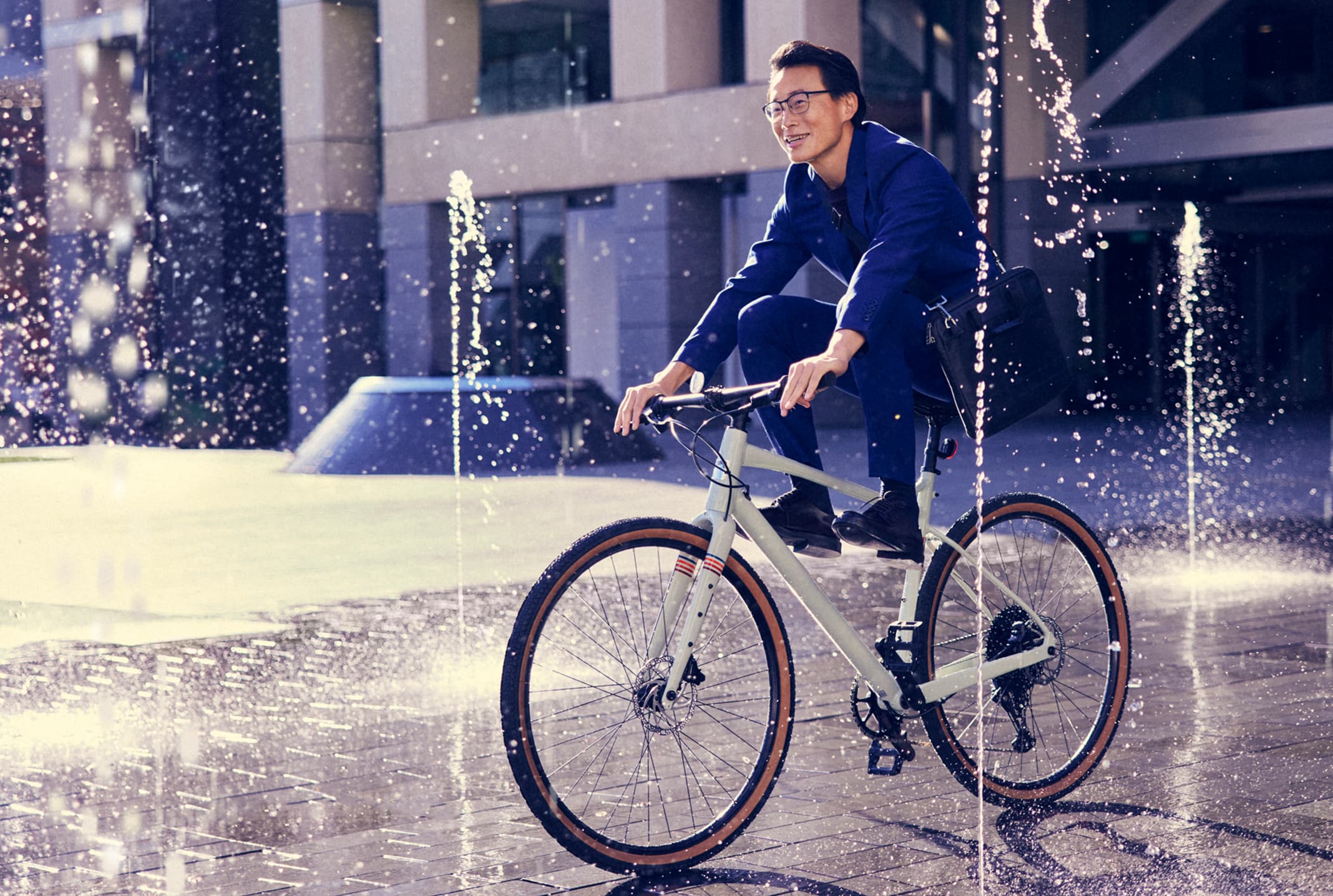 man riding bike through fountain
