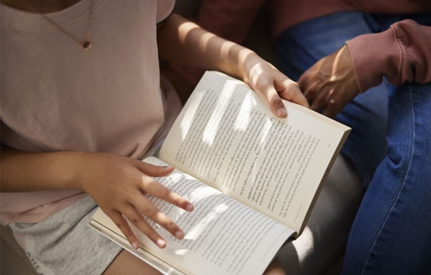 Girl and parent reading a book