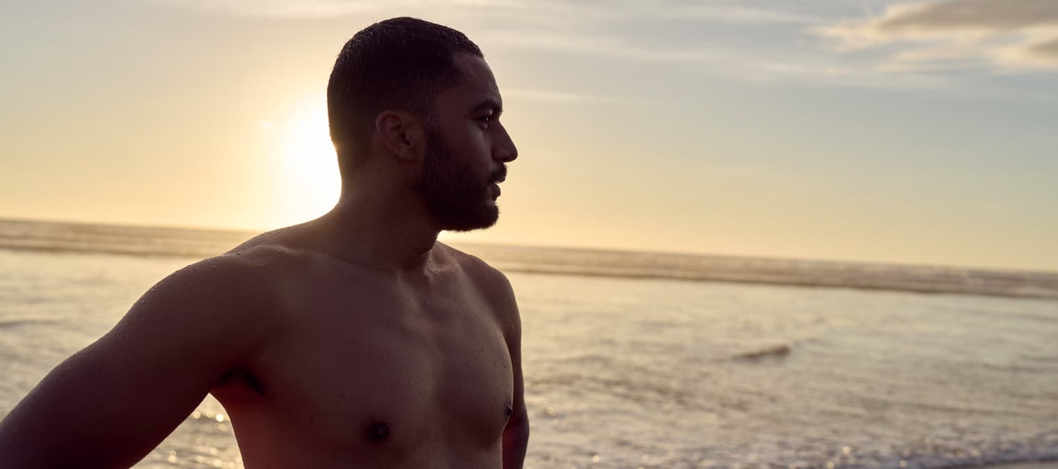 Man going swimming on beach looking at view