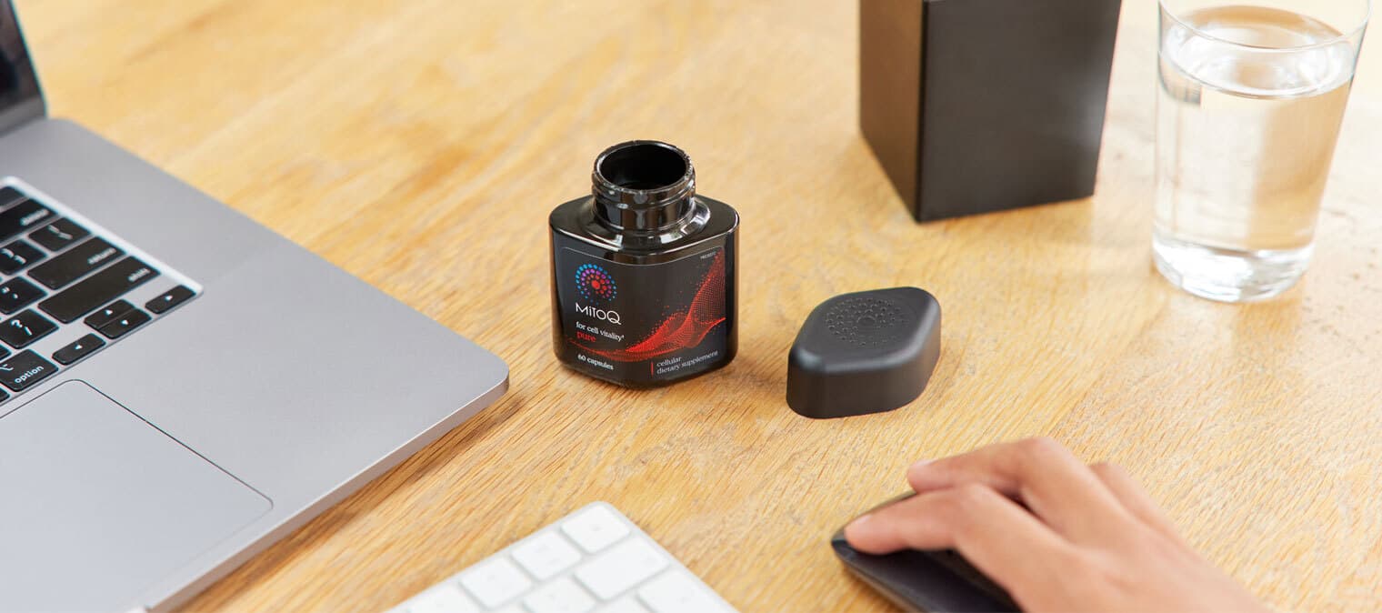 MitoQ Pure next to a laptop