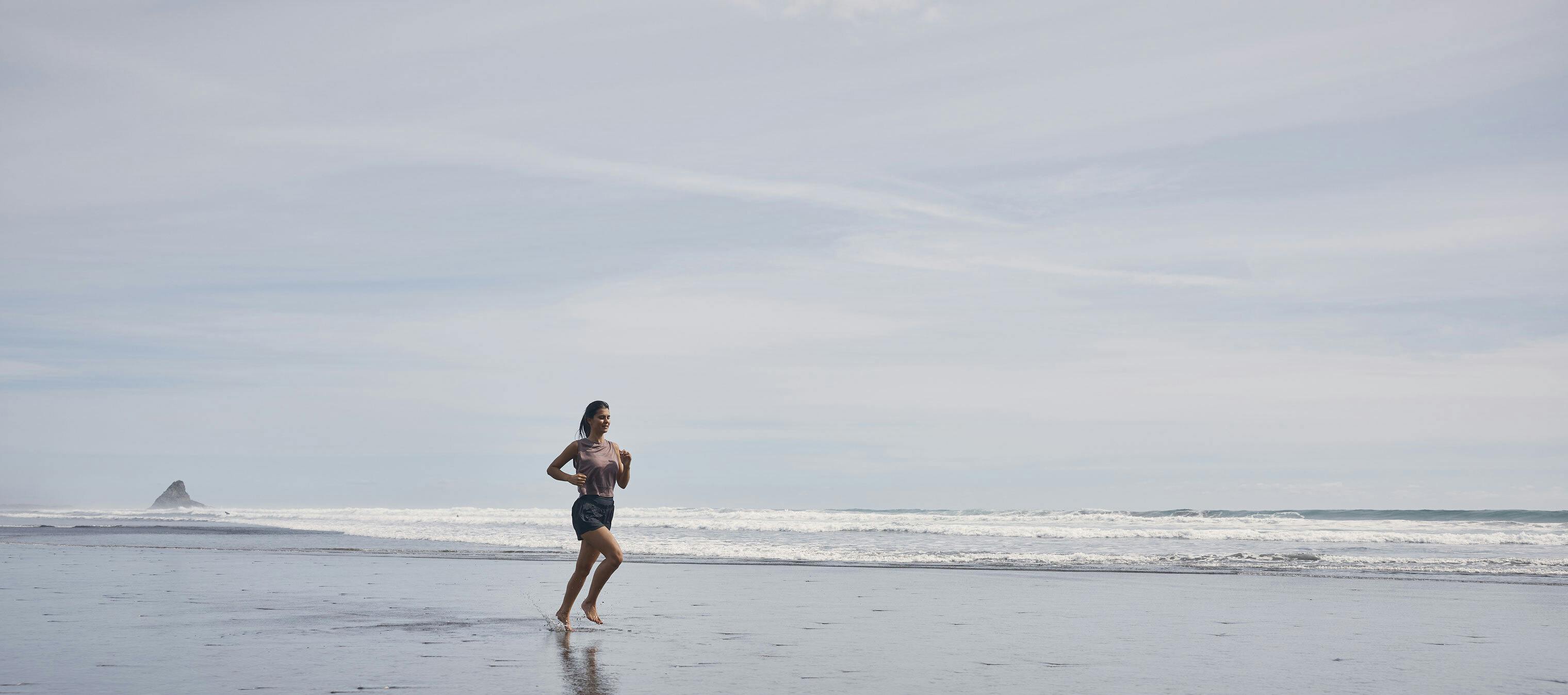 a woman running along the beach