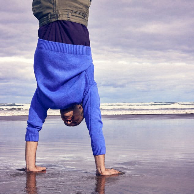man doing handstand on the beach