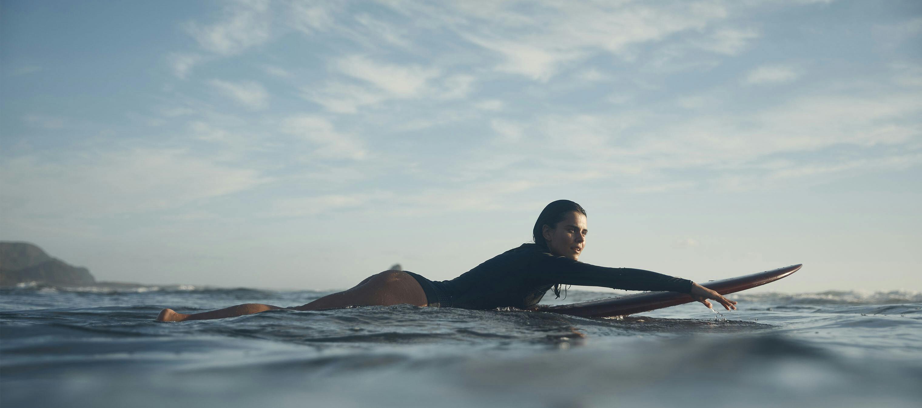 a woman paddling with her surf board