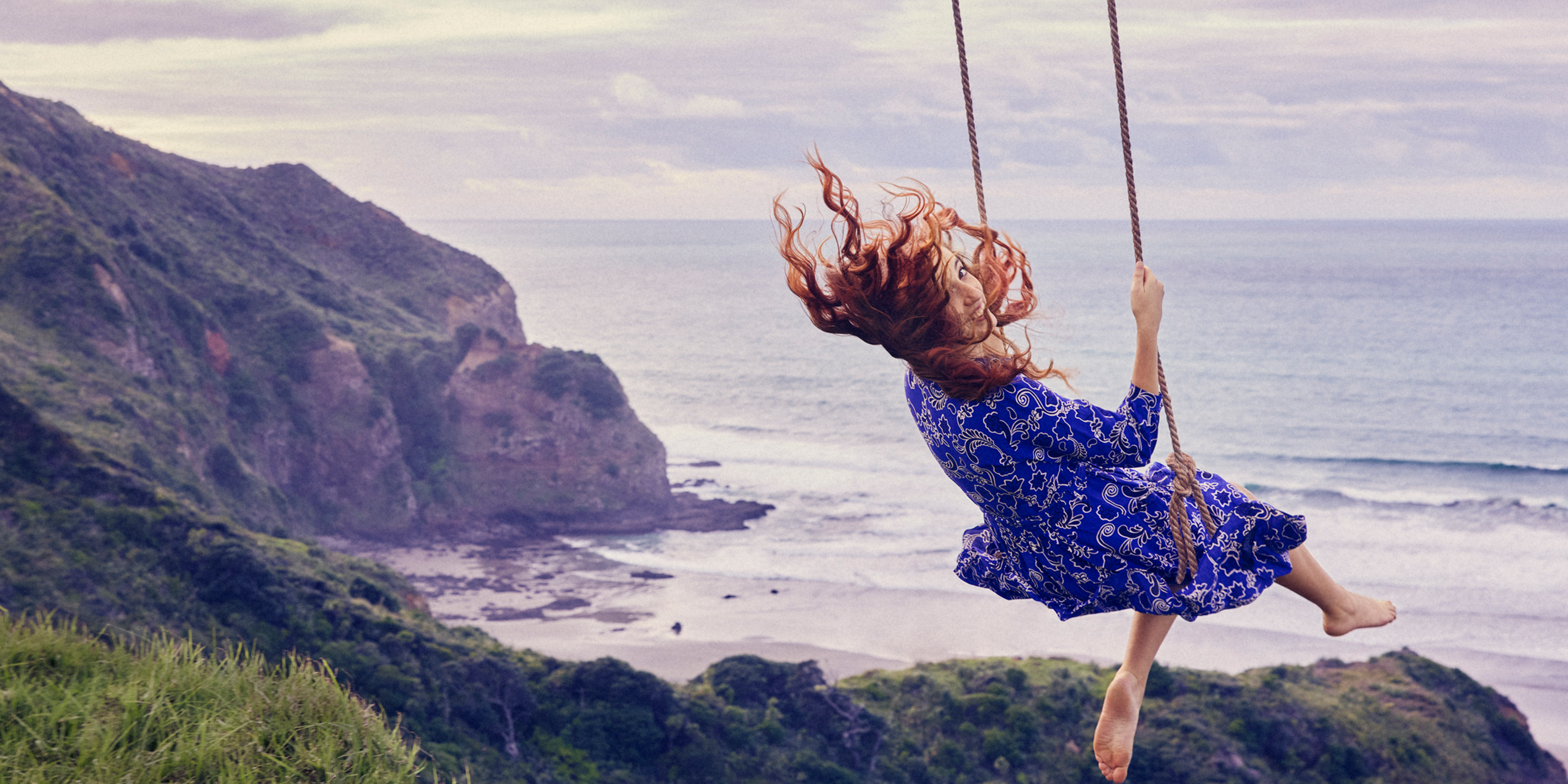 woman swinging on large swing over cliff with no limits