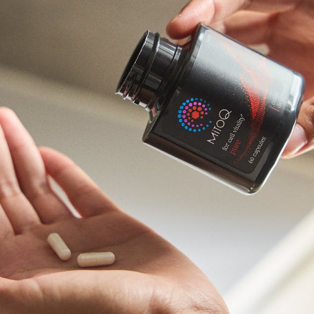 MitoQ Pure with pills in hand