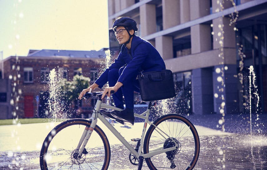 A man cycling next to a fountain