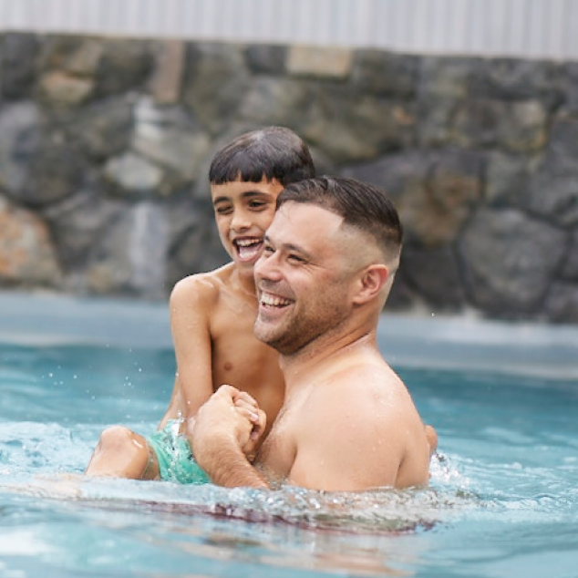 Father and son swimming in pool