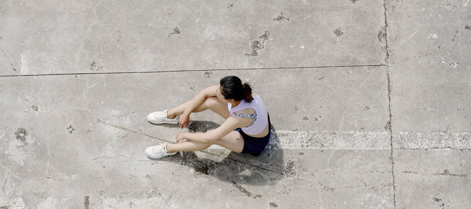 Woman sitting on concrete after a run