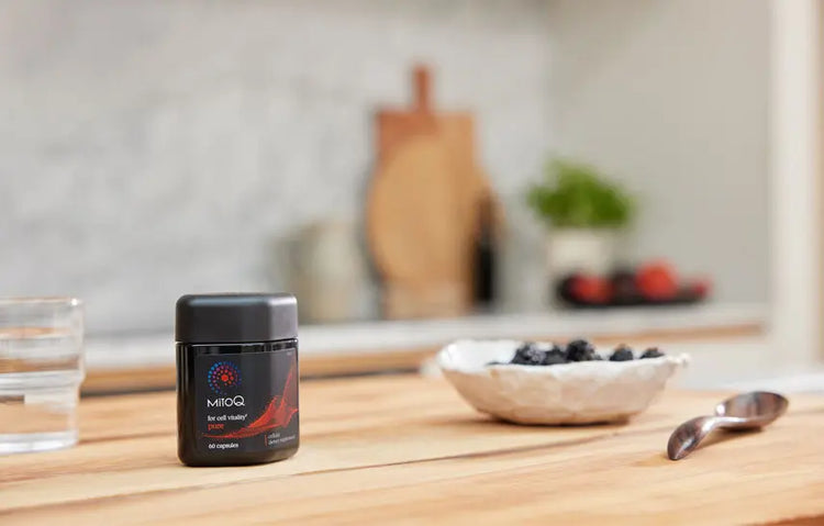 MitoQ Pure supplement bottle on a kitchen counter with a blurred background